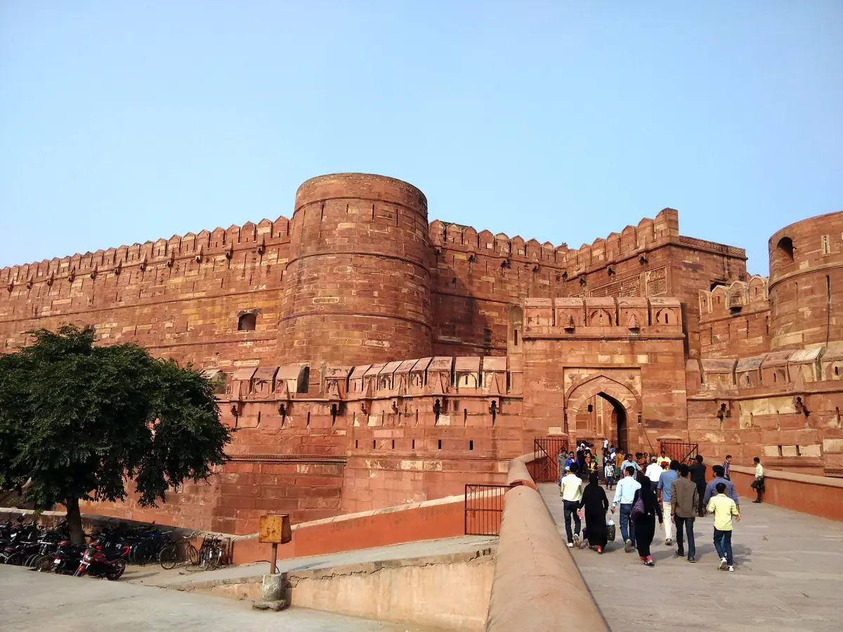 Red sandstone bastions and the Amar Singh Gate of Agra Fort under blue sky