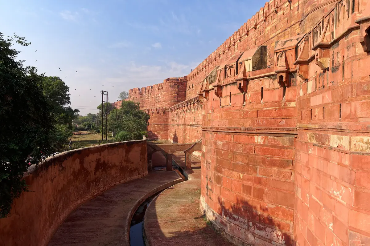Outer wall of Agra Fort with the dry moat and a curved path