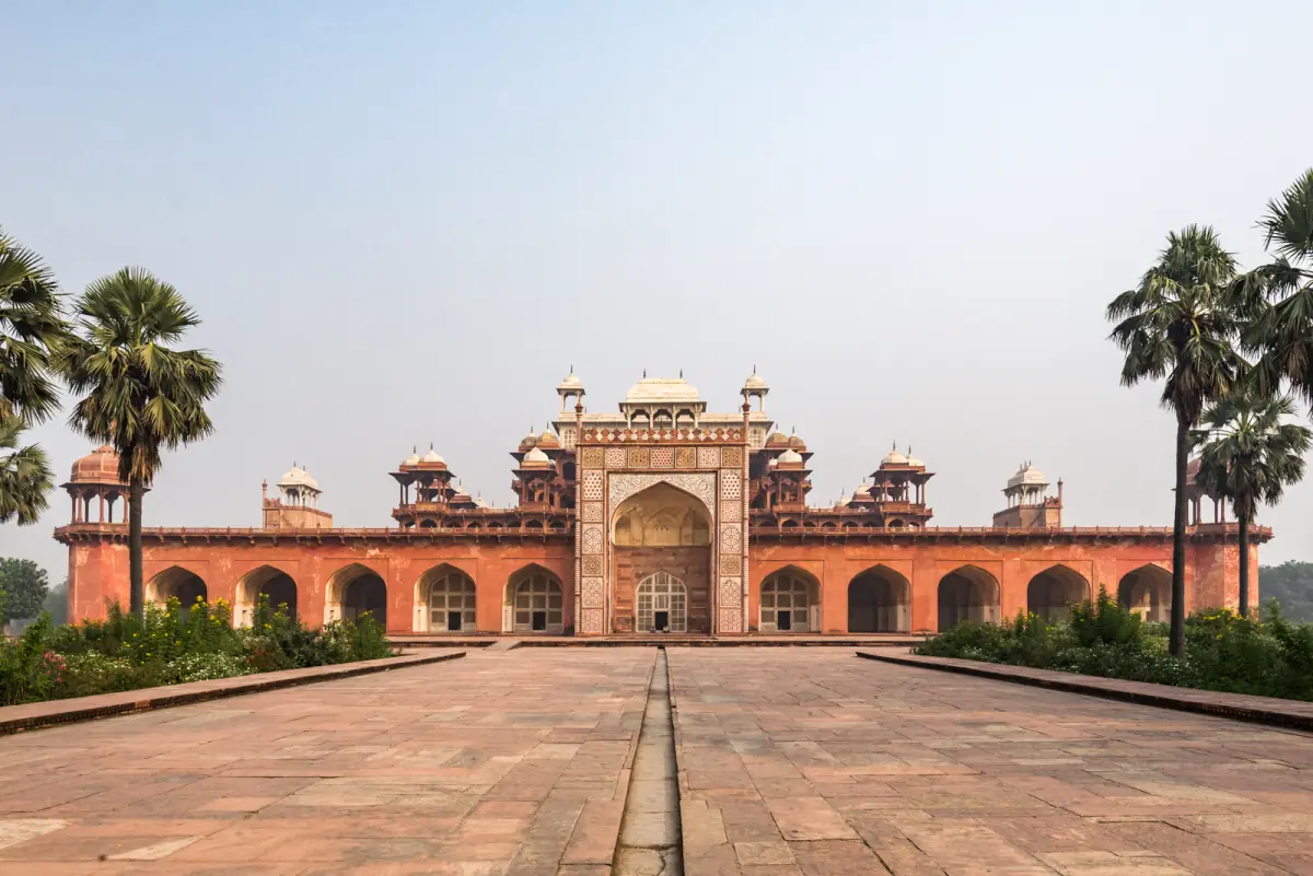 Red sandstone gateway of Akbar's Tomb at Sikandra seen along a paved avenue