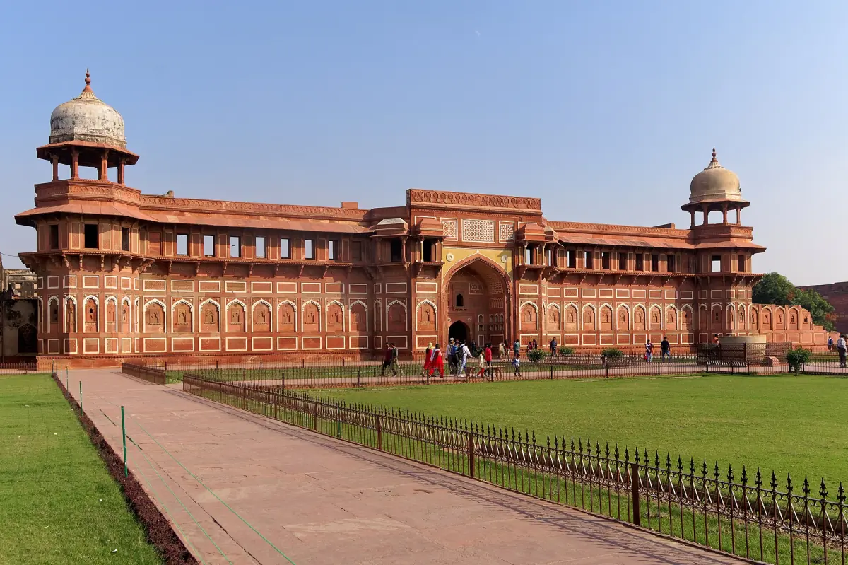 Long red sandstone facade of Jahangiri Mahal with domed corner pavilions and a lawn